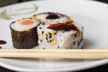 Uramaki and Hot Roll on a plate with chopsticks
