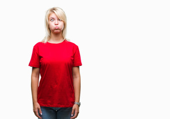 Fototapeta premium Young beautiful blonde woman wearing red t-shirt over isolated background puffing cheeks with funny face. Mouth inflated with air, crazy expression.