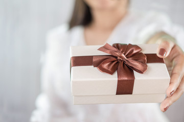 closeup woman hand giving gift box on Christmas day 