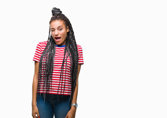 Young braided hair african american girl over isolated background winking looking at the camera with sexy expression, cheerful and happy face.