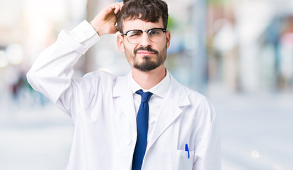 Young professional scientist man wearing white coat over isolated background confuse and wonder...