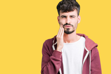 Young handsome man over isolated background touching mouth with hand with painful expression because of toothache or dental illness on teeth. Dentist concept.