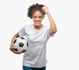 Young beautiful afro american holding soccer football ball over isolated background annoyed and...
