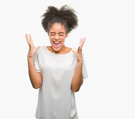 Young afro american woman over isolated background celebrating mad and crazy for success with arms raised and closed eyes screaming excited. Winner concept