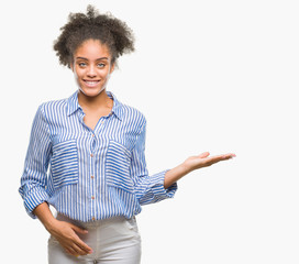 Young afro american woman over isolated background smiling cheerful presenting and pointing with palm of hand looking at the camera.