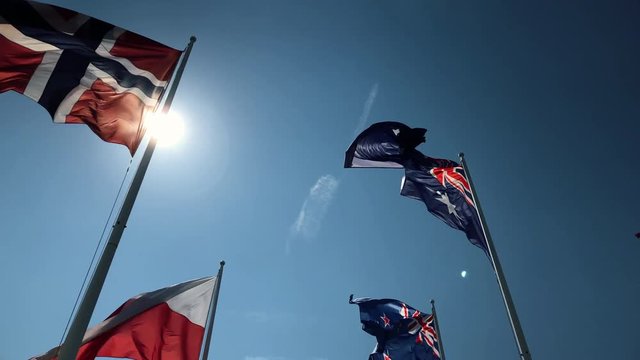 National flags flying united in slow motion with natural sun flare 