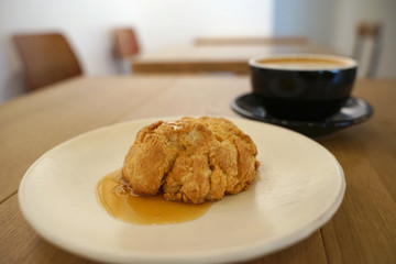 Homemade scone with honey syrub serving with hot coffee latte