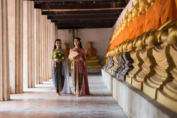 Thailand or Thai costume Asian dress concept. Young Thai beautiful woman  are walking in the Buddhist temple in Ayutthaya - obrazy, fototapety, plakaty
