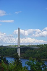 Bucksport, Maine, USA: White clouds in a bright blue sky over the Penobscot Narrows Bridge. The bridge is a 2,120 ft. long cable-stayed bridge over the Penobscot River. 
