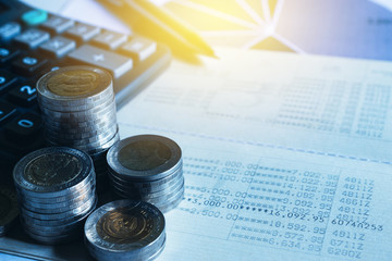 Closeup coins,calculator and passbook on desk in office for accounting,business concept.