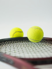 Close up of tennis ball and tennis racket isolated on white background