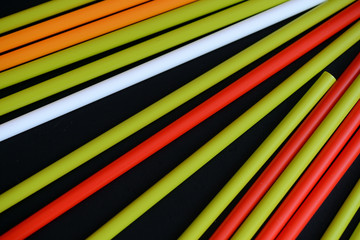 Colorful plastic straws on a dark background close up