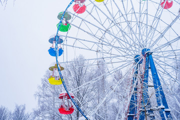 Ferris wheel in the winter park during a snowfall