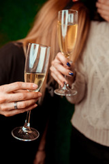 Hands of people with glasses of champagne or wine, celebrating and toasting in honor of the wedding or other celebration.