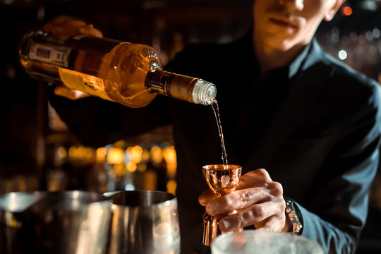 The bartender strains a cocktail in a glass at a nightclub, beach, pub, restaurant - Powered by Adobe