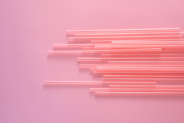 Drinking straws on bright pink background, top view