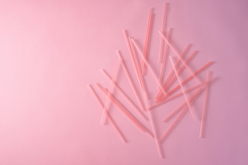 Drinking straws on bright pink background, top view