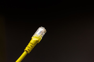 Yellow network cable or Lan cable with isolated on black background.