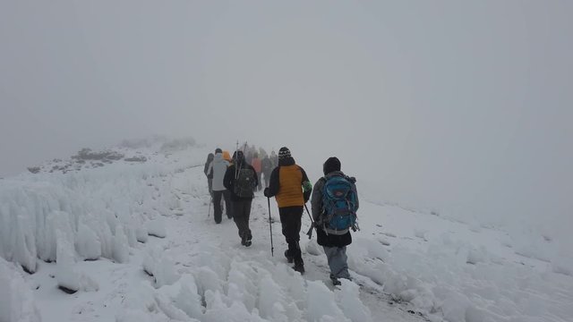 People Walking Through Snow Blizzard on Kilimanjaro Summit in Slow Motion