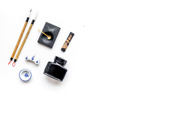 Accessories for chinese or japanese calligraphy. Special writting pen, ink on white background top view copy space