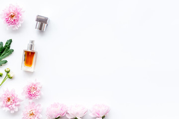 Floral perfume for women. Bottle of perfume near delicate pink flowers on white background top view space for text border pattern