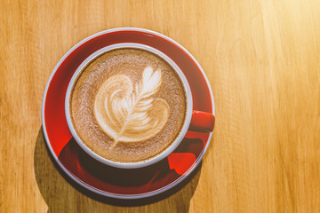 red cup of hot latte coffee with latte art