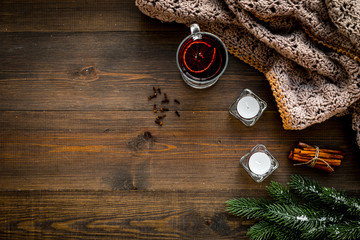Hot beverage for warm winter evening. Mulled wine near cinnamon, fir branches, wool blanket,...