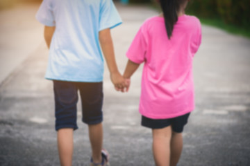Fototapeta premium Blur background Brothers and sisters walk hand in hand