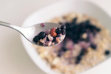 Spoon with granola, blueberries and hazelnut, toned. Close-up, copy space, soft focus