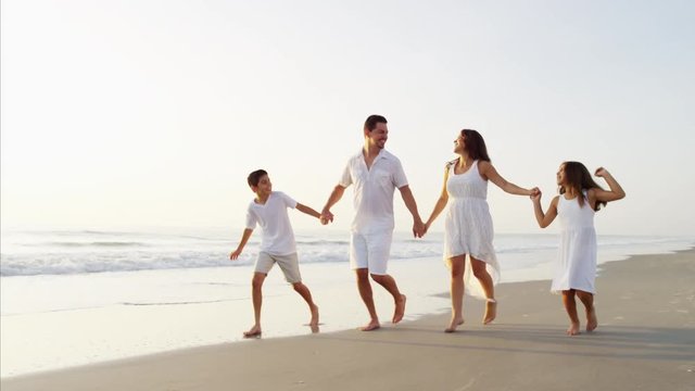 Attractive Latin American family walking on the ocean beach