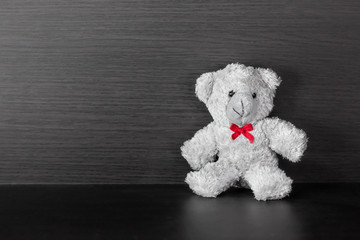 Teddy bear placed on wood background.