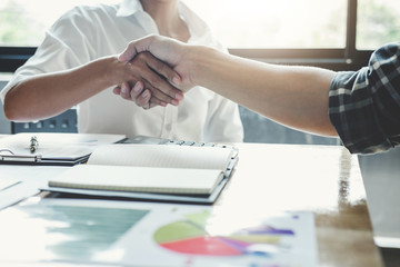 Business team two shaking hands after a meeting to sign agreement and become partner in the office, contract between their firms