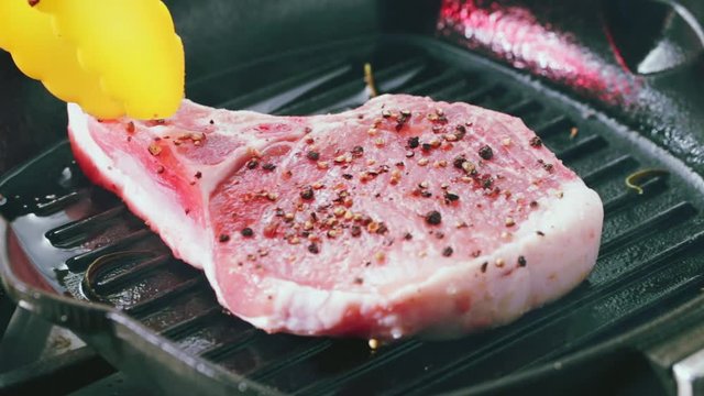 Pork T-Bone steak placed on hot grilling pan