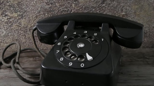 Dolly in shot of old vintage rotary black phone. Tracking shot