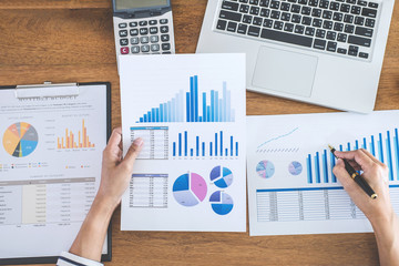 Female accountant calculations, audit and analyzing financial graph data with calculator and laptop...