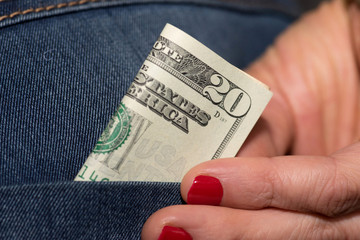 Dollar Geldschein in der Hosentasche einer Jeans von einer Frau