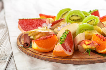 Fresh fruits in plate on wooden table
