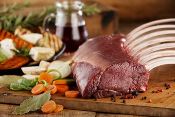 Ribs, seasoning and herbs on rustic chopping board