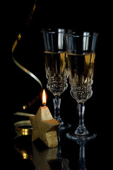 Two crystal glasses with champagne on black background
