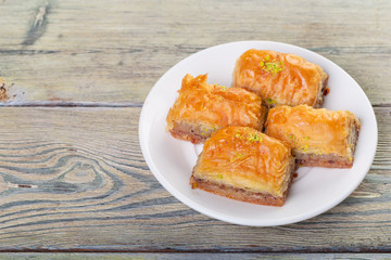 Traditional arabic dessert baklava with cashew, walnuts and cardamom with an eucalyptus branch on a wooden table