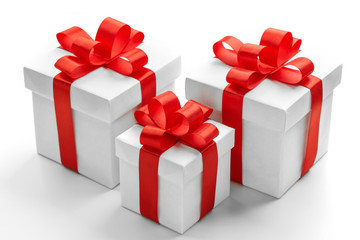 Three gift boxes with red ribbons on white background