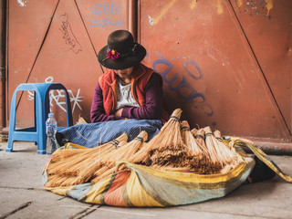 Woman selling brooms in the Cusco market