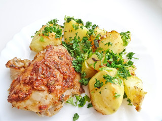 Appetizing dish - baked chicken and potatoes on a platter. Delicious and nutritious dinner