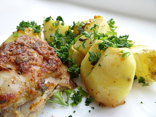 Appetizing dish - baked chicken and potatoes on a platter. Delicious and nutritious dinner