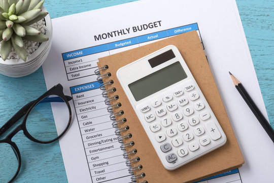 Monthly Budget Concept With White Calculator On Notebook