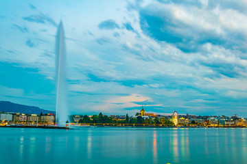 Sunset view of Geneva dominated by Jet d'eau fountain and Saint Pierre Cathedral, Switzerland