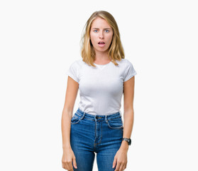 Beautiful young woman wearing casual white t-shirt over isolated background In shock face, looking skeptical and sarcastic, surprised with open mouth
