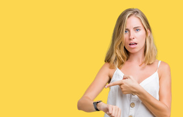 Beautiful young woman over isolated background In hurry pointing to watch time, impatience, upset...