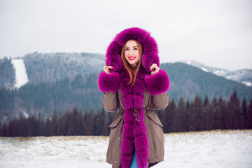 Fototapeta na wymiar Beautiful woman in fashionable park jaket at cold time outdoor , Fashion for lady, fur coat, autumn - winter season with good mood and luxury clothes, bright make up 
