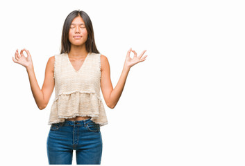 Young asian woman over isolated background relax and smiling with eyes closed doing meditation gesture with fingers. Yoga concept.